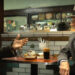 Robert De Niro sits in a diner playing both Frank Costello and Vito Genovese in The Alto Knights