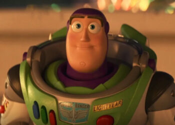 Buzz Lightyear smiles solemnly in the glow of carnival lights in Toy Story 4.