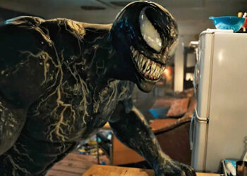 Venom, standing in Eddie's apartment, as he appeared in Venom: Let There Be Carnage (2021).