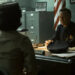 Taylour Paige as Charlotte Hanlon seated across Peter Outerbridge as Police Chief Clint Bowers in his office in It: Welcome to Derry