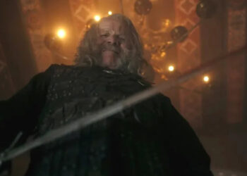 Peter Mullan as Vesemir looking down at the camera with his sword in The Witcher season 4