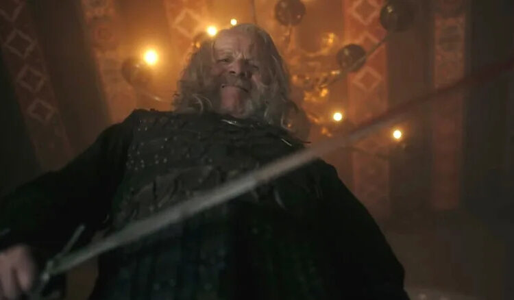 Peter Mullan as Vesemir looking down at the camera with his sword in The Witcher season 4
