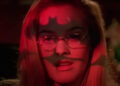 Alicia Silverstone's Barbara Wilson with bat-symbol light projected on her face in Batman & Robin