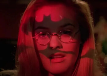 Alicia Silverstone's Barbara Wilson with bat-symbol light projected on her face in Batman & Robin