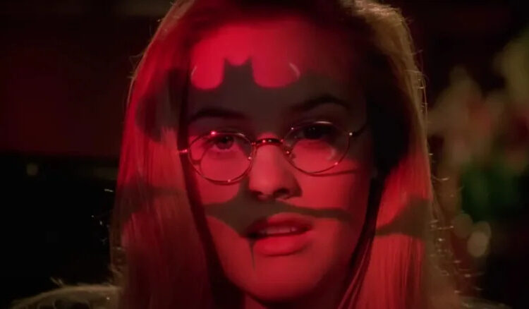 Alicia Silverstone's Barbara Wilson with bat-symbol light projected on her face in Batman & Robin
