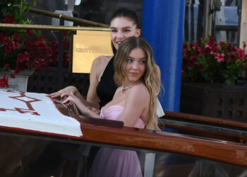 Actress Sydney Sweeney and another young woman in formal dresses.