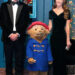 The Prince and Princess of Wales posing either side of Paddington - Catherine has her hand on the back of the bear's head