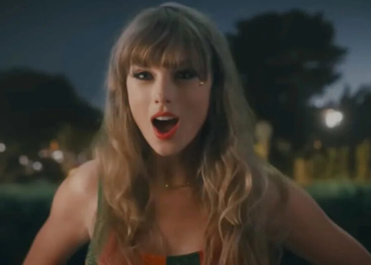 Taylor Swift standing with her mouth open in the Anti-Hero music video.