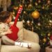 A little boy sitting in a chair next to a christmas tree