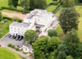 An aerial photograph of Royal Lodge, Prince Andrew's residence in Windsor, shows a large white building with green fields and trees surrounding it and a variety of cars parked outside it. File photo