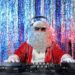 DJ Santa Claus mixing up some Christmas cheer. Disco lights in the background.