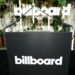 A podium with the "billboard" logo, surrounded by plants and vertical lights.