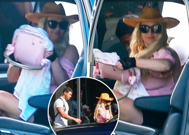 Britney Spears bizarrely totes toy baby carrier as she returns from Cabo with ripped fitness influencer
