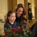 Princess Charlotte and Catherine, The Princess of Wales, sit smiling at a piano as they perform at for a Christmas Carol service