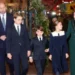 PA Media Prince William, Prince George and Prince Louis are seen walking outside the Abbey wearing suits, shirts and ties, while their sister Charlotte, wearing a dress with a peter pan collar, looks up at their mother Catherine, who wears a green coat with a furry collar
