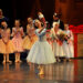 A young ballerina portraying Clara lifts the Nutcracker doll during a Santa Cruz ballet performance.