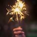 A sparkler is raised into the air.