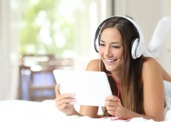 Happy girl listening to the music from a tablet in the bedroom at home