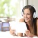 Happy girl listening to the music from a tablet in the bedroom at home