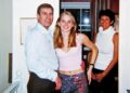 A man and two women stand in a house looking at the camera.