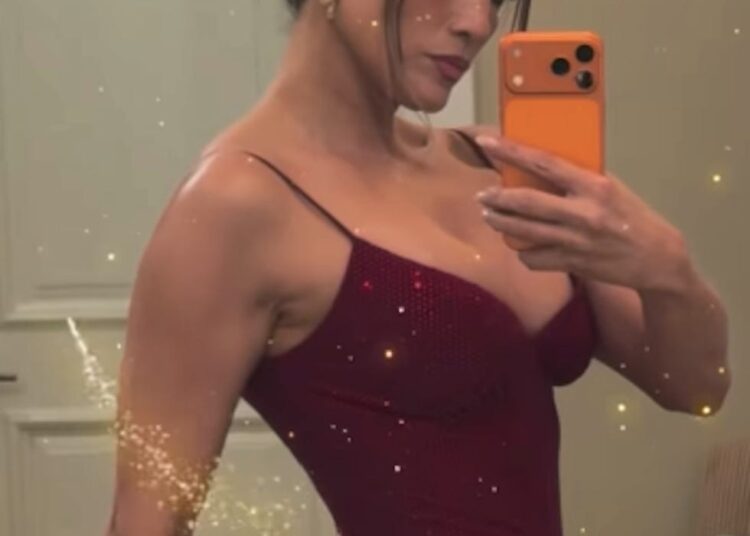 a person taking a selfie in a red dress with sparkles