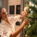 Meghan Markle decorating a Christmas tree in her Netflix holiday special, carefully placing ornaments while smiling and enjoying the festive activity.