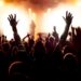silhouettes of concert crowd in front of bright stage lights