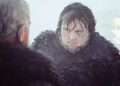 Two bearded men in fur-lined clothing look at each other intensely in a snowy setting, suggesting a dramatic or tense moment