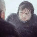 Two bearded men in fur-lined clothing look at each other intensely in a snowy setting, suggesting a dramatic or tense moment