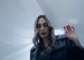 A musician with long blonde hair is shown in a still from one of her music videos.