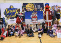 Children gather with Pacers Sports & Entertainment staff, Indiana Pacers mascot Boomer, Indiana Fever mascot Freddy Fever, Indiana Pacemates, Muncie Mayor Dan Ridenour and Muncie Police Department Deputy Chief Melissa Criswell for the Big Toy Giveaway at Muncie Central High School on Tuesday, Dec. 9, 2025.