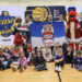 Children gather with Pacers Sports & Entertainment staff, Indiana Pacers mascot Boomer, Indiana Fever mascot Freddy Fever, Indiana Pacemates, Muncie Mayor Dan Ridenour and Muncie Police Department Deputy Chief Melissa Criswell for the Big Toy Giveaway at Muncie Central High School on Tuesday, Dec. 9, 2025.
