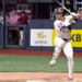 A baseball player in a white uniform with a maroon helmet and a bat in hand, standing at home plate, with "KB" and "KB LIFE" visible on the surrounding signage.
