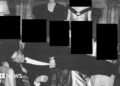 A black and white image showing Andrew lying across the laps of people