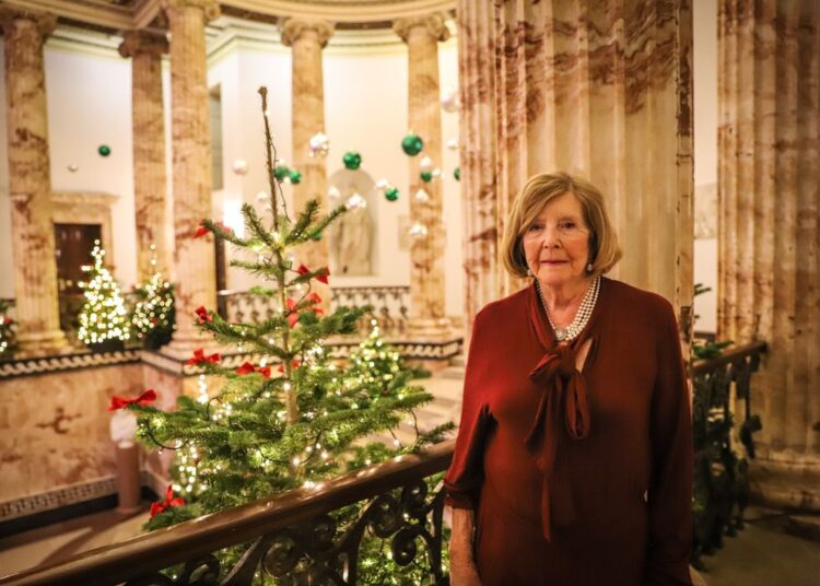 Lady Anne Glenconner in front of Christmas tree at Holkham Hall