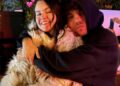 two individuals embracing surrounded by colorful lighting