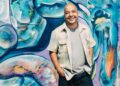 Man standing against graffiti wall