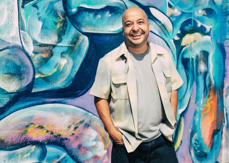 Man standing against graffiti wall