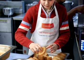 Prince George handling Yorkshire puddings at a homeless shelter