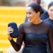 Meghan Markle wore a chic black Jason Wu midi dress with sheer sleeves, paired with Aquazzura crystal-embellished slingbacks, a Gucci clutch, and Nikos Koulis earrings for the Lion King premiere in July 2019