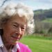 Dame Shân, with short grey hair and wearing a pink jumper and shirt.