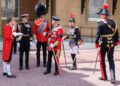 King Charles talks to Prince William while Princess Anne looks on