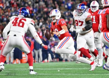 New England Patriots quarterback Drake Maye (10) runs with the ball against New York Giants linebacker Zaire Barnes (46).