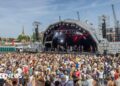 A large crowd watching a band performing on the Harbour Festival's main stage during the day
