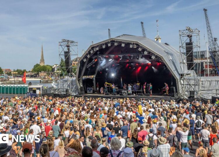 A large crowd watching a band performing on the Harbour Festival's main stage during the day