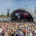 A large crowd watching a band performing on the Harbour Festival's main stage during the day