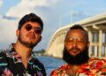 Two men wearing tropical shirts by a highway