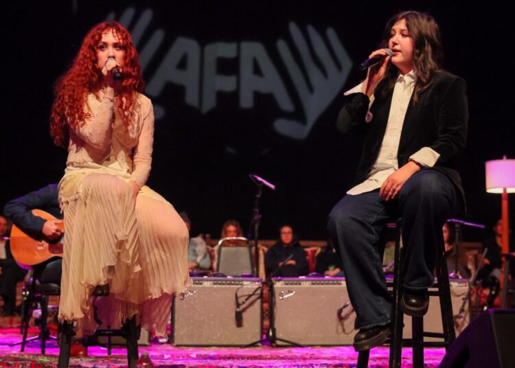 Chappell Roan, left and Lucy Dacus, right perform onstage during Artist for Aid benefit concert at Shrine Auditorium.