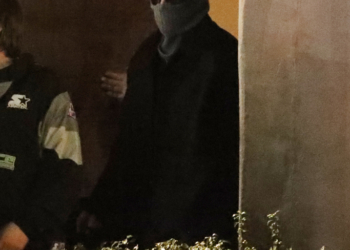 Bad Bunny in a horned beanie and dark sunglasses at night.
