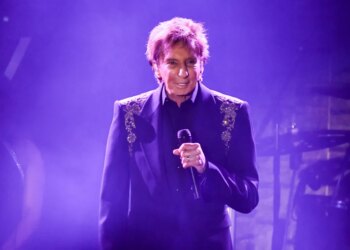 Barry Manilow performing on stage with a microphone.
